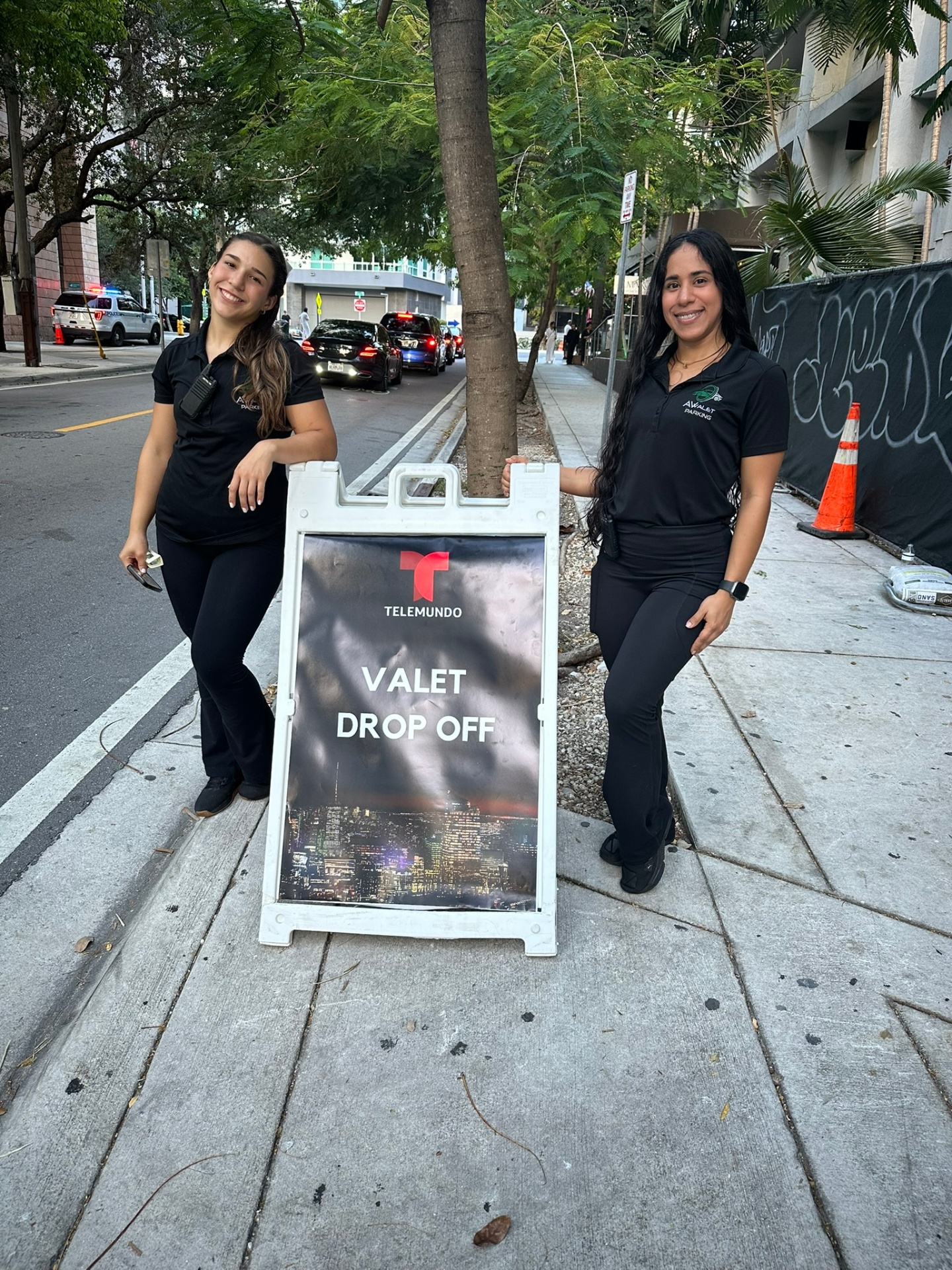 Two AV Valet attendants beside a Telemundo valet drop-off sign in Brickell